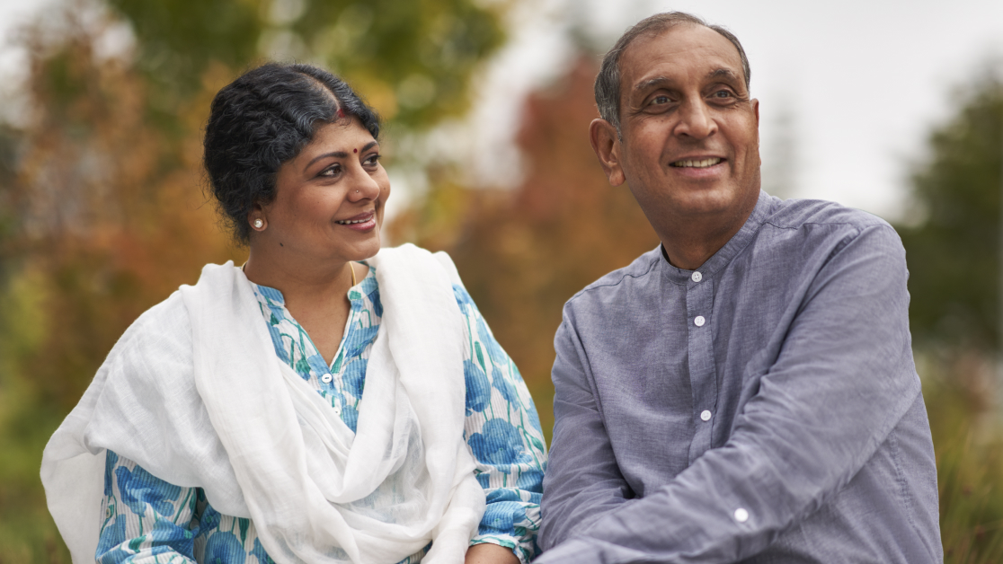 Mature couple outdoors sitting in a park