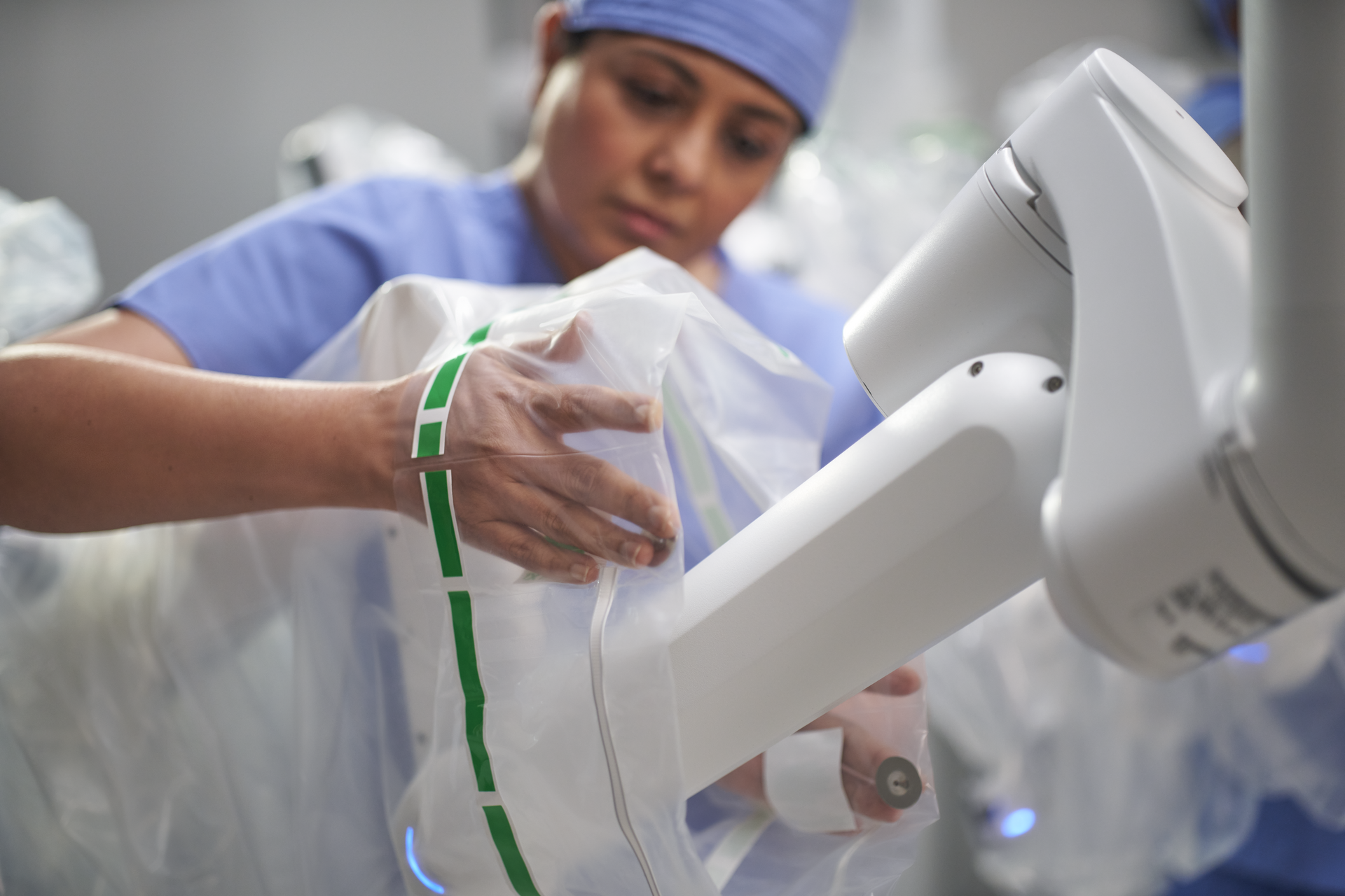 An OR technician places covering on Da Vinci Xi system